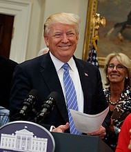 President Donald Trump, accompanied by Education Secretary Betsy DeVos, arrives to speak during a school choice event in the Roosevelt Room of the White House on Wednesday. | Evan Vucci/AP