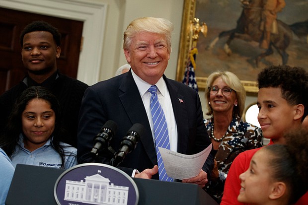 President Donald Trump, accompanied by Education Secretary Betsy DeVos, arrives to speak during a school choice event in the Roosevelt Room of the White House on Wednesday. | Evan Vucci/AP