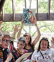 May Day protests in Richmond //  At left, Kim Bobo, left, and the Rev. Jack Posiadlo of Sacred Heart Catholic Church in South Richmond bless participants in the National Day Without Immigrants, timed to coincide with May Day observances on Monday, May 1. Location: Abner Clay Park in Jackson Ward. Similar events were held across the country to support immigrants and protest President Trump’s aggressive deportation policies. At right, boisterous protesters march on City Hall on Monday evening to urge the ouster of federal immigration agents and voice other concerns about federal and state policies.
