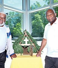 Eugene Mallory, left, and Raymond Mitchell, trustees at Mount Olive Baptist Church in Henrico County, show the replica they designed and made of “Brush Arbor,” the first structure built by the congregation at its start 150 years ago.