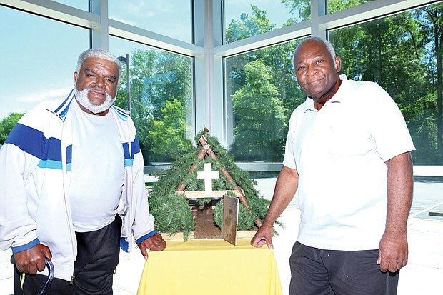 Eugene Mallory, left, and Raymond Mitchell, trustees at Mount Olive Baptist Church in Henrico County, show the replica they designed and made of “Brush Arbor,” the first structure built by the congregation at its start 150 years ago.