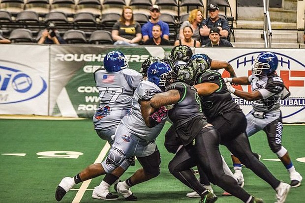 The Richmond Roughriders, in black and green, ride roughshod over the South Carolina Cowboys during last Saturday’s game at the Richmond Coliseum. The Roughriders won 92-0.