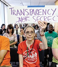 Brigette Newberry, center, a teacher at Richmond’s Open High School, shows the Richmond School Board that she wants it to release more information on the circumstances surrounding Superintendent Dana T. Bedden’s departure.