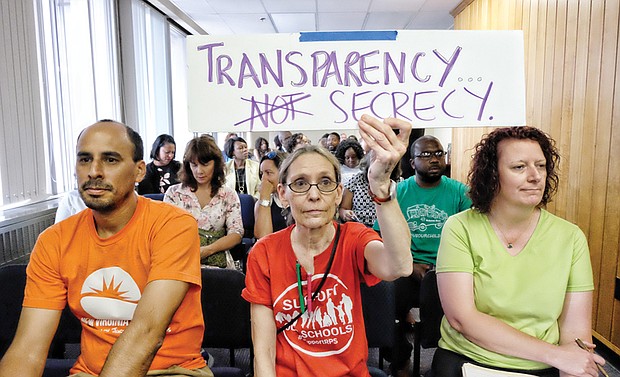 Brigette Newberry, center, a teacher at Richmond’s Open High School, shows the Richmond School Board that she wants it to release more information on the circumstances surrounding Superintendent Dana T. Bedden’s departure.