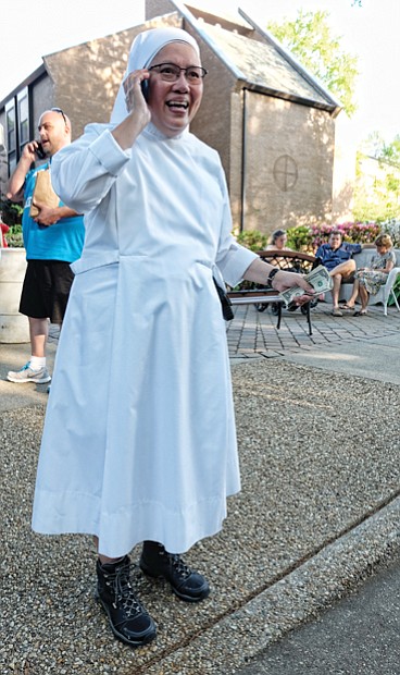 Ooh la la //  Sister Rose Marie, dressed in her habit and high-top hiking boots, talks on the phone after accepting a donation at the French Food Festival last Saturday at the Little Sisters of the Poor on Michaels Road in Henrico County.