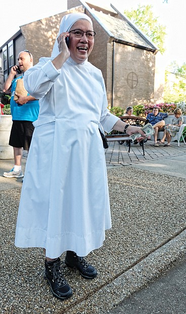 Ooh la la // Sister Rose Marie, dressed in her habit and high-top hiking boots, talks on the phone after accepting a donation at the French Food Festival last Saturday at the Little Sisters of the Poor on Michaels Road in Henrico County.