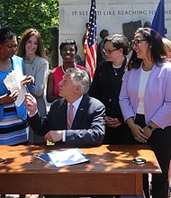 Making history //
Gov. Terry McAuliffe gives Richmond Delegate Delores L. McQuinn his pen Wednesday after signing a history-making bill into law that she patroned through the General Assembly. The new law ensures that 19th-century graves, monuments and markers of African-Americans will get the same state support as the burial sites of Confederate soldiers who fought to keep them enslaved. The governor also signed a second bill Richmond Delegate Jennifer L. McClellan ushered through the legislature that clears the way for the Virginia Foundation for the Humanities to preserve and tell the story of sites in the state linked to enslaved people.  Among those taking part in the signing ceremony are, from left, Richmond Delegate Betsy B. Carr; Powhatan Delegate R. Lee Ware; Delegate McQuinn; Fairfax Delegate Eileen Filler-Corn; Petersburg Delegate Lashrecse D. Aird; Delegate McClellan; Virginia Outdoor Foundation Executive Director Brett Glymph; state Secretary of Natural Resources Molly Ward, hidden; and First Lady Dorothy McAuliffe.  The ceremony took place in front of the Civil Rights Monument in Capitol Square.