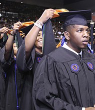 Deron Bennett gets hooded by Octavia Bryson during Virginia State University’s commencement Saturday at the VSU Multi-Purpose Center.