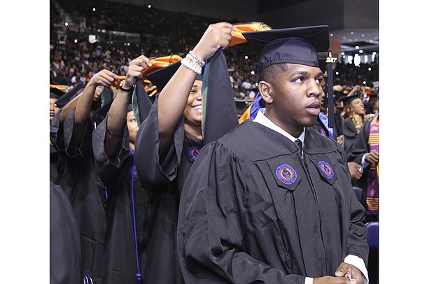 Deron Bennett gets hooded by Octavia Bryson during Virginia State University’s commencement Saturday at the VSU Multi-Purpose Center.