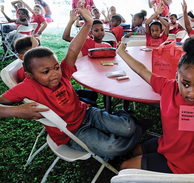 Pick me! //
Ahmad Anderson, left, and his Carver Elementary School classmate Zay’Mya Harris wave their hands with the answer during an activity at the Children’s Book Festival last Friday at Abner Clay Park in Jackson Ward. The first-graders were among students from four area school systems to participate. Please see more photos, B2.  