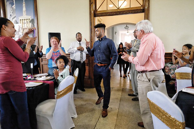 Hometown basketball hero Frank Mason III signs the jersey of 7-year-old Davy Rasmussen during a celebration last Friday at Petersburg’s Union Station honoring the Petersburg native. The youngster was accompanied by his grandfather, Dick Gooley.