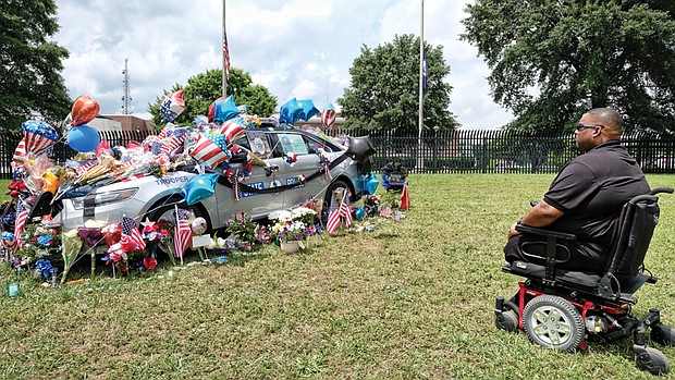 Former Special Officer Brad Hughes, who lost his legs in the line of duty in 2014, visits the memorial to Virginia State Police Special Agent Michael T. Walter that sits outside of the State Police Headquarters on Midlothian Turnpike in Chesterfield County. Mr. Hughes said Tuesday that he knew Agent Walter and wanted to pay his respects.