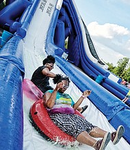 Fun in a different light // Sisters Jessica Fox and Toya Obasi ride down the slide before nightfall, when the blacklights’ effects are more visible. Hundreds of people turned out to enjoy the slide, music and fun on the warm evening. A portion of the event’s proceeds are to benefit the Children’s Miracle Network.