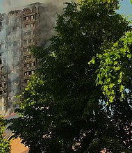 	A still smoking Grenfell Tower, several hours after the fire started.