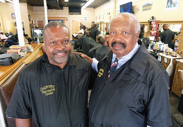 Clarence Oliver Jr. works side by side with his dad, Clarence Oliver Sr., at Supreme Hairstyling Lounge in Jackson Ward. The shop has been at its 1st Street location since 1976.