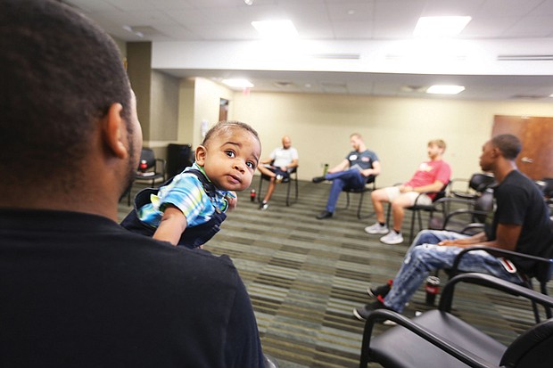 Daddy boot camp // Expectant fathers get lessons on fatherhood during a Boot Camp for New Dads last Saturday at Chippenham Hospital in South Side. Sponsored by the Relationship Foundation of Virginia, the session provided dads-to-be with practical tips from new dads and their youngsters on a host of things, including how to change and dress a baby. Top left, Kenneth Jackson Jr. of Midlothian, holding his 7-month-old son, Nasir, serves as an “expert” during the session.

