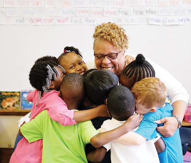 A hug to last through summer // Richmond’s J.E.B. Stewart Elementary School Principal Jennifer Moore gives kindergartners a big group hug last Friday, the last day of school. She reminded students to keep in mind her motto during the summer break: “Read, read, read.” During the summer, many students forget some of what they have learned during the school year. Called the “summer slide,” research indicates that reading just six books during the summer can help prevent loss of progress in reading.
