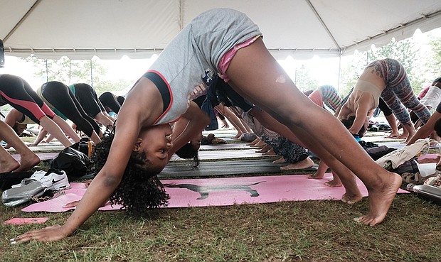 Another group goes into the downward-facing dog pose, while another class,