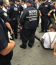 In New York, police said 12 people were arrested and charged with disorderly conduct. They were detained outside the historic Stonewall Inn as they carried signs that read "No Cops, No Banks."