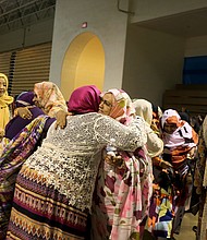 Muslim women greet one another last Sunday at festivities celebrating Eid al-Fitr, the holiday that marks the end of Ramadan. The event was held at Richmond’s Arthur Ashe Jr. Athletic Center. 