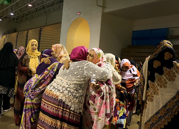 Muslim women greet one another last Sunday at festivities celebrating Eid al-Fitr, the holiday that marks the end of Ramadan. The event was held at Richmond’s Arthur Ashe Jr. Athletic Center. 