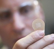 Mark Prausnitz, a Georgia Tech Regents professor in the School of Chemical and Biomolecular Engineering, holds a microneedle vaccine patch containing needles that dissolve into the skin.