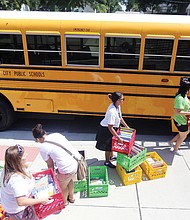 Teachers at Oak Grove-Bellemeade Elementary School load books onto the school’s R.E.A.D. Bus for its initial run Wednesday in neighborhoods in which the school’s students live. R.E.A.D. Buses from 20 of the city’s 24 elementary schools are part of the Reading Riders program to encourage students to read during the summer. 