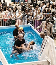 Alajah Johnson, front, holds her nose while she is baptized by David Lowe, and Kijah Powers gets ready for her baptism with Spencer Spinner. The two were among 29 people baptized last Saturday during the Jehovah’s Witnesses convention at the Richmond Coliseum in Downtown. It was the first of a series of three-day weekend conventions by the denomination. The series concludes Aug. 4 through 6.