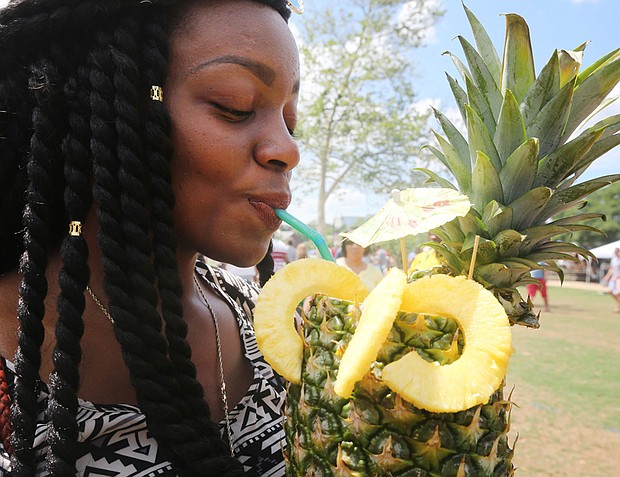 Tasting culture //
LaTeese Moore of Richmond sips a refreshing fruity drink from Jem’s Catering at the RVA Street Food Festival last Saturday at Brown’s Island. The festival, which drew hundreds of people to the city’s waterfront, offered cuisine from a variety of cultures and countries in a unique, outdoor experience.
