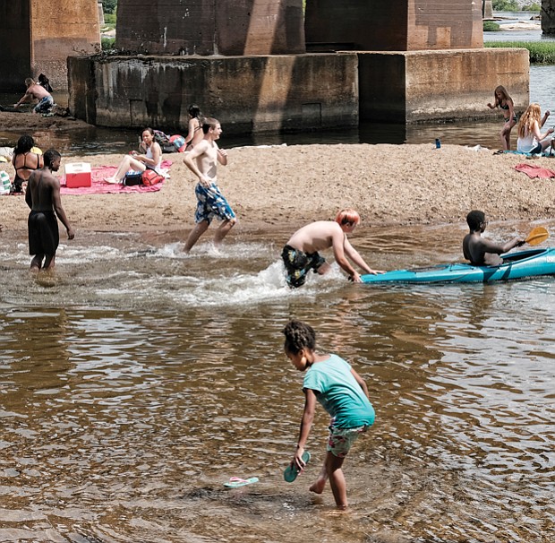 Area residents enjoy the cooling James River near Brown’s Island on Monday,