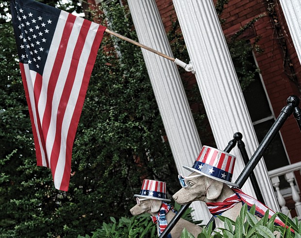 Homes and people sported the colors of the holiday. At right, the American flag flies at a house in the 2600 block of Broad Street in the East End, where dog statues also sport patriotic red, white and blue. 
