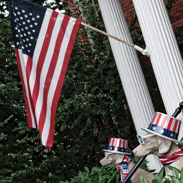 Homes and people sported the colors of the holiday. At right, the American flag flies at a house in the 2600 block of Broad Street in the East End, where dog statues also sport patriotic red, white and blue. 
