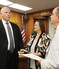 Thomas E. Kranz is sworn in as the interim superintendent of Richmond Public Schools by Richmond Circuit Court Clerk Edward F. Jewett. Laura Kranz, his wife, holds the Bible during the ceremony filled with friends, family, School Board members and RPS employees.