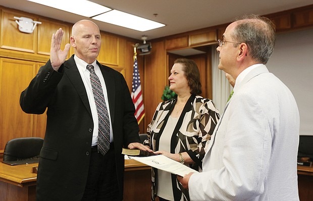 Thomas E. Kranz is sworn in as the interim superintendent of Richmond Public Schools by Richmond Circuit Court Clerk Edward F. Jewett. Laura Kranz, his wife, holds the Bible during the ceremony filled with friends, family, School Board members and RPS employees.