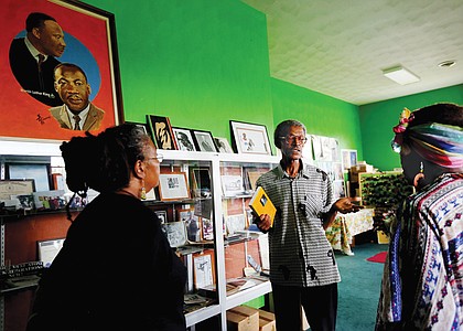 H. Khalif Khalifah, center, speaks to visitors in the Nat Turner Library in his home during last Saturday’s fundraising event, “The Resurrection of Nat Turner: Save the Land.”
