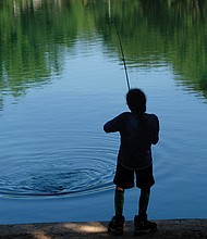 Gone fishin’
Deican Jones works his rod and reel from the cool shade at Shields Lake in Byrd Park during a recent fishing expedition. In this instance, the fish that was nibbling at his line got away.  