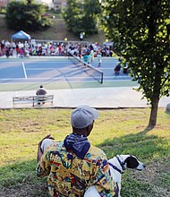 John Trent and his pet Bennie, right, watch the festivities from the hillside.