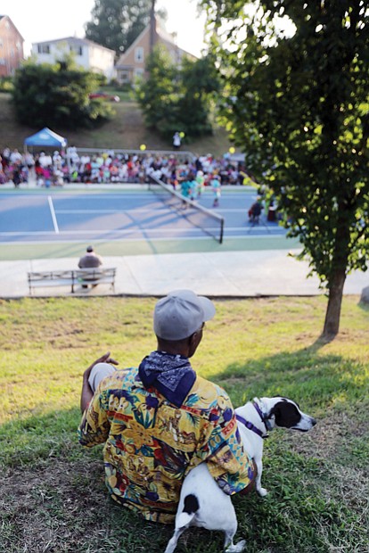 John Trent and his pet Bennie, right, watch the festivities from the hillside.