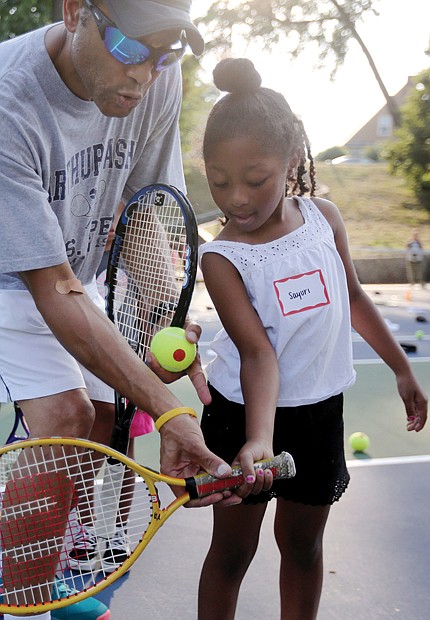 Sayuri Gholson, 6, receives tennis instruction from James Skinner of Midlothian, a volunteer with the Metro Richmond Tennis Club. Above, park visitors take a peek inside the painted tunnel before the unveiling begins