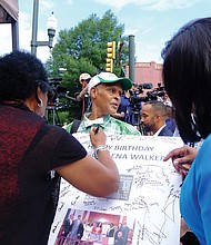 9. Melvin S. Jones Jr., a longtime advocate for the Walker statue, holds a giant birthday card honoring Mrs. Walker while Delegate Delores McQuinn, left, signs and Sen. Rosalyn Dance awaits the pen.