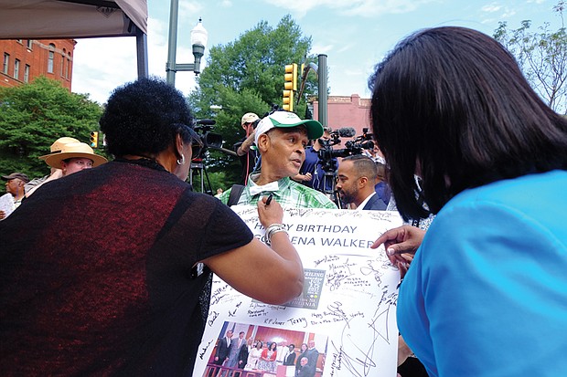 9. Melvin S. Jones Jr., a longtime advocate for the Walker statue, holds a giant birthday card honoring Mrs. Walker while Delegate Delores McQuinn, left, signs and Sen. Rosalyn Dance awaits the pen.