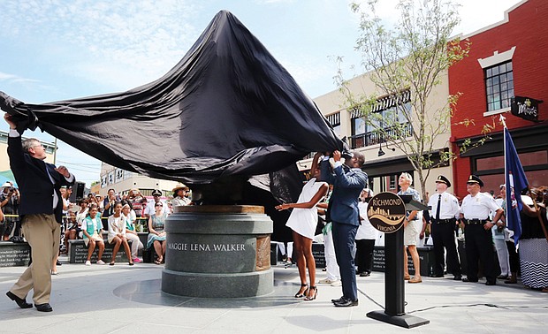 1. Sculptor Antonio “Toby” Mendez, left, assists Richmond Mayor Levar M. Stoney and Liza Mickens, Mrs. Walker’s great- great-granddaughter in unveiling the statue.