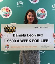 Daniela Leon Ruz of Orlando holding a check for $500 a week for life.