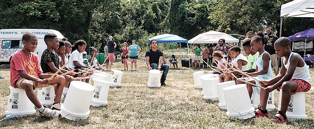 Cultivating musical interest //
Shyamuu Bhagat leads youngsters in a bucket drum workshop last Saturday at “Drums in the Garden,” an event at the 5th District Mini Farm on Bainbridge Street in South Side to promote urban farming and healthy eating.