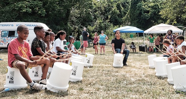 Cultivating musical interest //
Shyamuu Bhagat leads youngsters in a bucket drum workshop last Saturday at “Drums in the Garden,” an event at the 5th District Mini Farm on Bainbridge Street in South Side to promote urban farming and healthy eating.