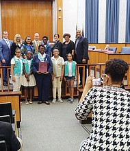 
Honoring historic Girl Scout troops
Scout leader Glennys Fleming, center, holds the resolution honoring Girl Scout Troops #34 and #35 that was presented Monday night by Richmond City Council to Ms. Fleming and several scouts from the troops sponsored by Ebenezer Baptist Church. Historic Troop #34, the first African-American troop in the South, was chartered in March 1932 after Emma Watson wanted her daughter to participate in scouting as she had before moving to Richmond from Chicago. With the support of influential Richmond women such as Maggie L. Walker and Lena Watson, dean of students at Virginia Union University, Ms. Watson advocated for the local Girl Scouts council to create a local African-American troop. It met at VUU. In 1936, Troop #35 was established at Ebenezer Baptist Church, which began sponsoring Troop #34 in 2015.