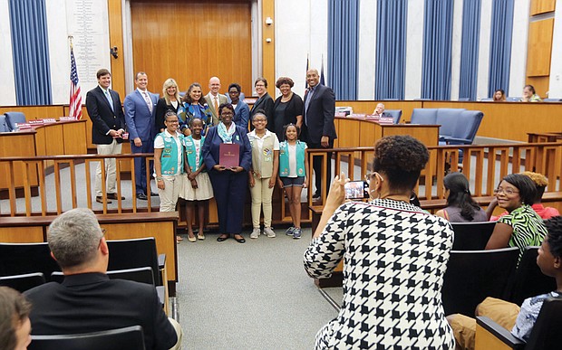 
Honoring historic Girl Scout troops
Scout leader Glennys Fleming, center, holds the resolution honoring Girl Scout Troops #34 and #35 that was presented Monday night by Richmond City Council to Ms. Fleming and several scouts from the troops sponsored by Ebenezer Baptist Church. Historic Troop #34, the first African-American troop in the South, was chartered in March 1932 after Emma Watson wanted her daughter to participate in scouting as she had before moving to Richmond from Chicago. With the support of influential Richmond women such as Maggie L. Walker and Lena Watson, dean of students at Virginia Union University, Ms. Watson advocated for the local Girl Scouts council to create a local African-American troop. It met at VUU. In 1936, Troop #35 was established at Ebenezer Baptist Church, which began sponsoring Troop #34 in 2015.