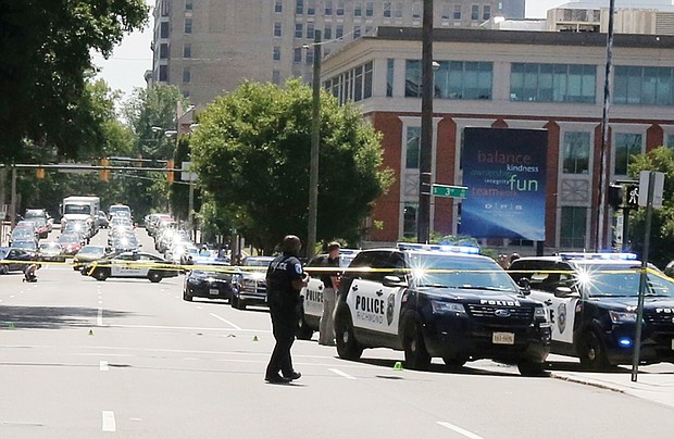 Cityscape // Crime tape and police and firefighters in action are all too common in Richmond and other cities. Above, officers and police cars pack the intersection of 3rd and Main streets in Downtown around 10:30 a.m. Tuesday following the police shooting of a man wielding a large knife and an ax. Police Chief Alfred Durham said officers shot the man when he did not respond to commands to drop the weapons, and a Taser proved ineffective in stopping him. When the man attacked the officers, two fired, hitting him. The man, later identified as Alexander J. Schoessel, 23, of Chesterfield, was pronounced dead at 10:31 a.m. Tuesday at a Richmond hospital. Officer John Rotondi also was hit by friendly fire during the incident. He was taken to a hospital, where he was treated and released. Right, firefighters hose down a smoldering pile of driftwood Tuesday afternoon underneath a pedestrian bridge across the James River that connects Brown’s Island and Belle Isle in Downtown. 