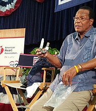 Carew holding his LVAD during a news conference.