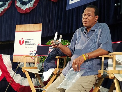 Carew holding his LVAD during a news conference.